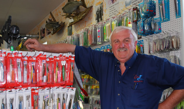 Smiling Randy Zelonka beside a display of small fishing tackle items