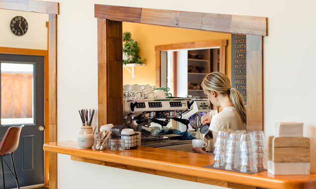 Woman working behind coffee counter. 