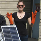 Four students post behind a table containing two types of solar panels.