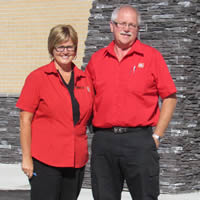 Walter and Heather Ingram, wearing their red Home Hardware shirts, stand in front of their new building.