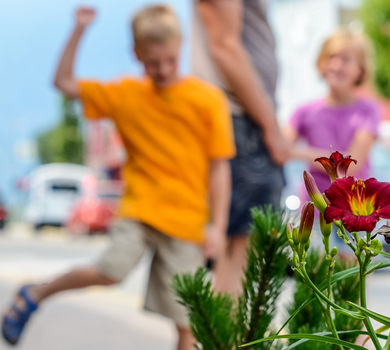 Flowers in the foreground, children and dad in soft-focus background