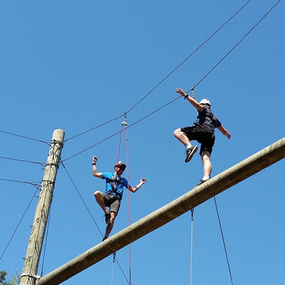 Two people on a high-ropes course. 