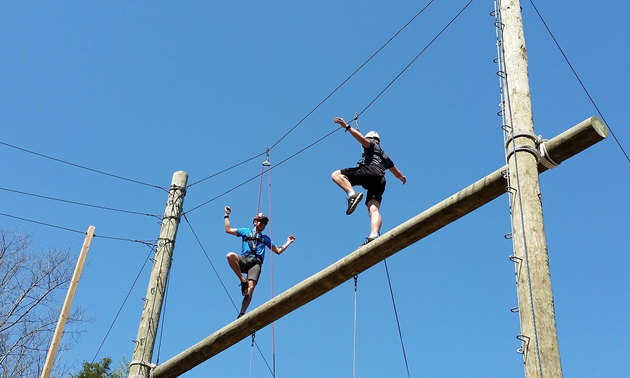 Two people on a high-ropes course. 