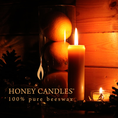 Several beeswax candles are burning with a soft golden glow. These candles are from Honey Candles near Kaslo, B.C.