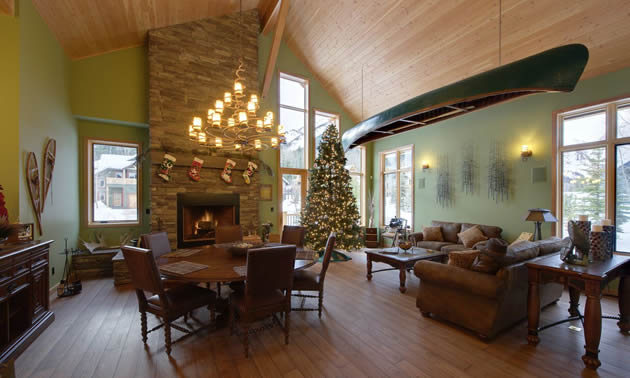Dining and living room with a stone fireplace and Christmas tree
