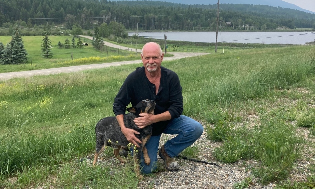 Man sitting with his dog, a cute blue heeler