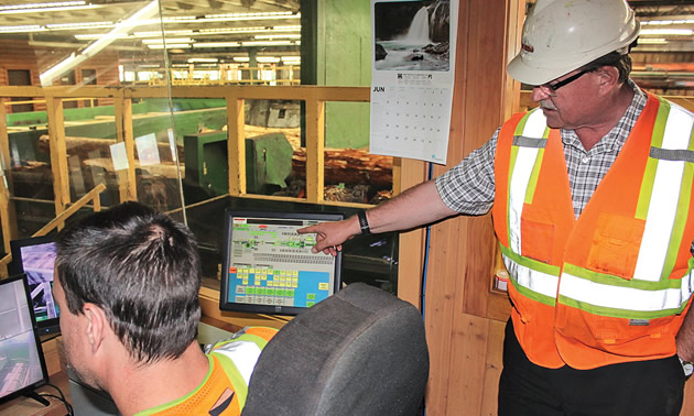 Worker pointing at computer. 