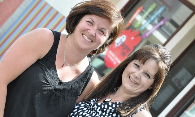 Michelle Hansen and Wendy Franz stand outside their Imagine Ink store.
