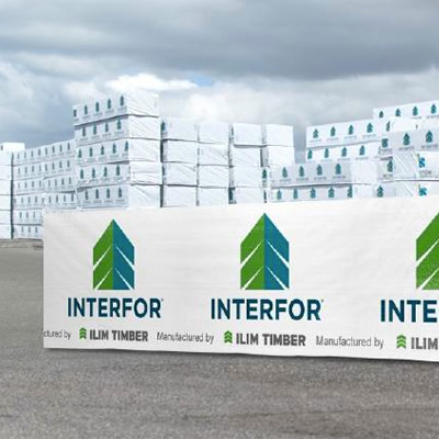 Picture of lumber stacked in yard, covered with Interfor logo. 