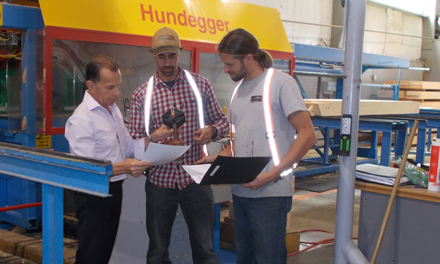 John Jarman (L), operations manager at Canadian Timberframes Ltd., with two crew members