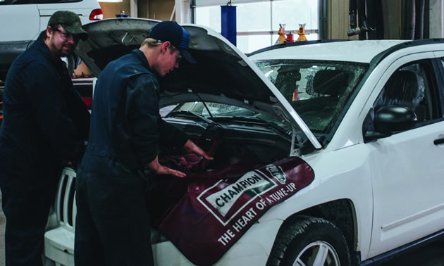 Automotive Service Technician (AST) students Roger Blackmore and Cameron Birch practice their skills on a 2010 Jeep Compass SUV. 