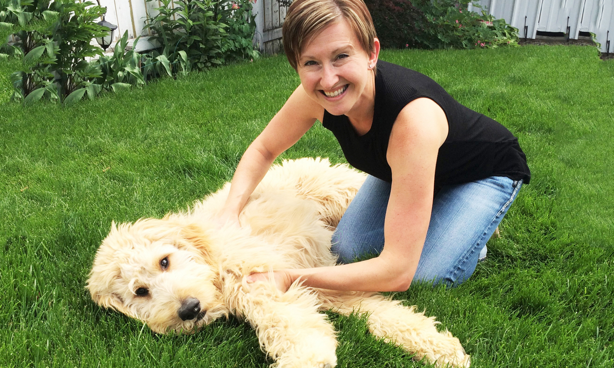Joanna Sleik playing with Buddy, her adorable golden doodle dog