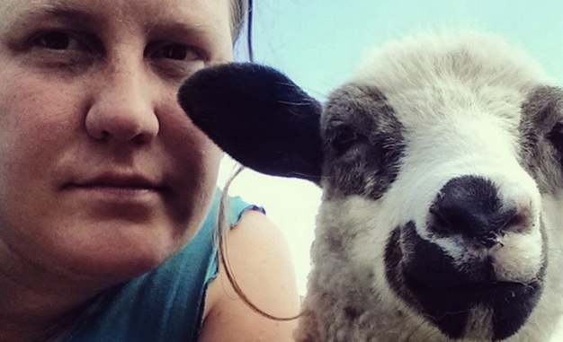 A close up photo of Jo Ferris and a lamb. 