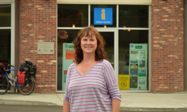 Judy Goodman, executive director of Revelstoke Chamber of Commerce in Revelstoke, B.C., stands in front of the visitor centre and chamber of commerce building.