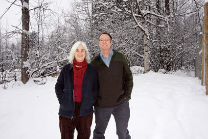 A man and woman stand in a snowy landscape