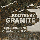 White lettering spells out Kootenay Granite on a chunk of dark granite.