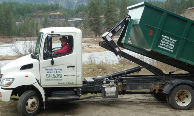 A white Hino dump truck is driven by Ron Liddle of Kettle Valley Waste.