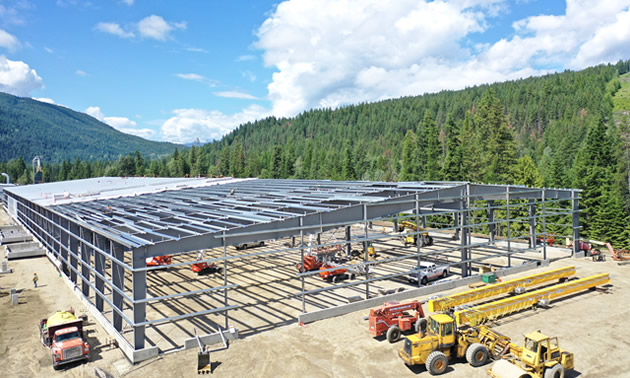 The partially built mass timber facility is shown, with the metal framework in place.