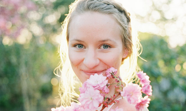 Close up shot of Kathryn Henry holding a bouquet of flowers. 
