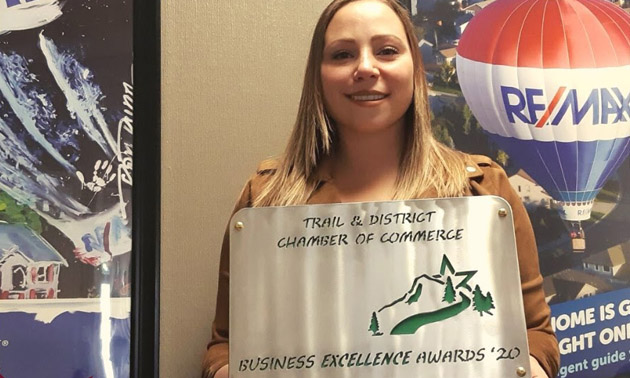 Katie Yuris holding Business Excellence Award 
