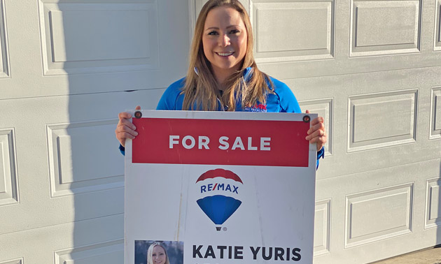 Katie Yuris holding realtor sign. 