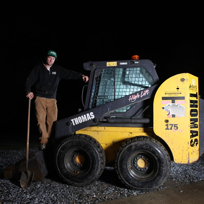 Owner of Kays Contracting, Matt Hanlon, poses with one of his contracting machines.