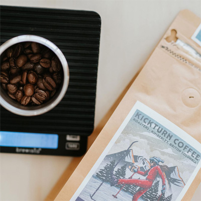 Close-up of Kickturn Coffee Roasters bag and scale with bowl of coffee beans. 