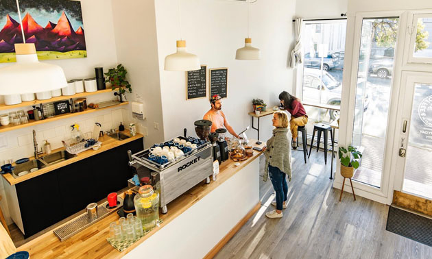 Interior of Kickturn Coffee in Kimberley, showing roomy area painted a bright white and modern furniture. 