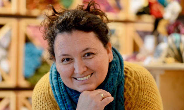 A headshot of Christina Chalifour with a blue knitted scarf around her neck.