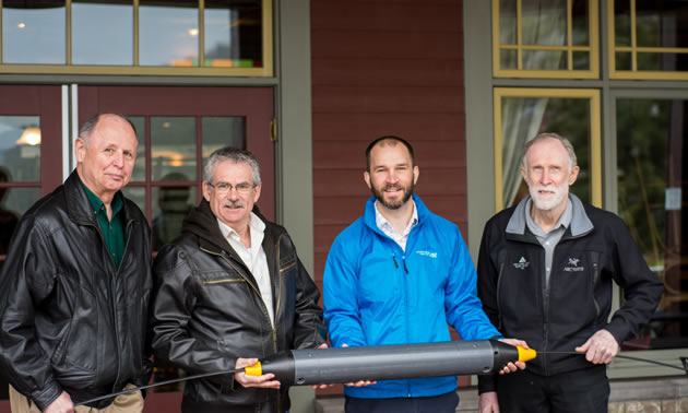 Columbia Basin Broadband Corporation Chief Operating Officer, Dave Lampron, Kaslo Infonet Society (KiN) President Don Scarlett, KiN Board Member Tim Ryan together with Robert Abbey, Assistant Manager of the Kaslo Hotel, showcase a section of fibre optik cable similar to the one used in this project. (Left to right: Don, Robert, Dave, Tim)