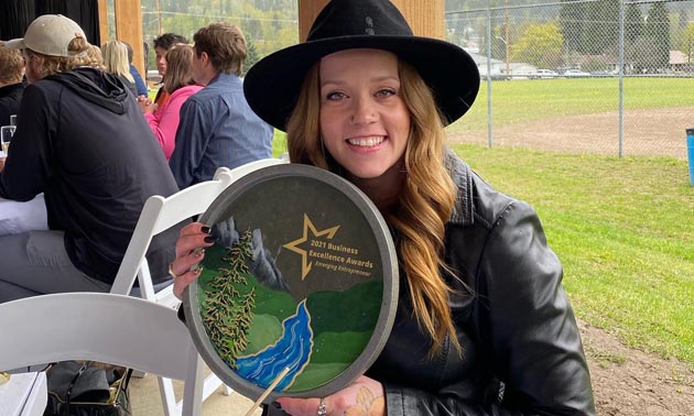 Leanne Hawkins holding award and smiling. 