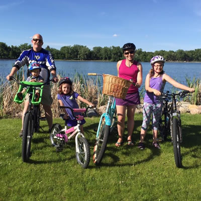 Kristy Jahn-Smith and her family on bikes on sunny day. 