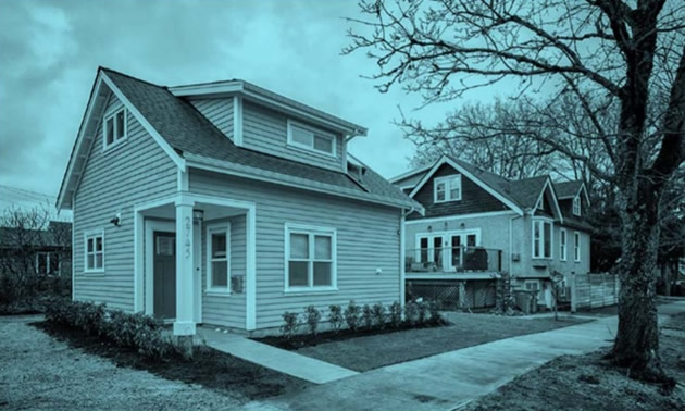 Sepia-coloured photo of heritage house on city street. 