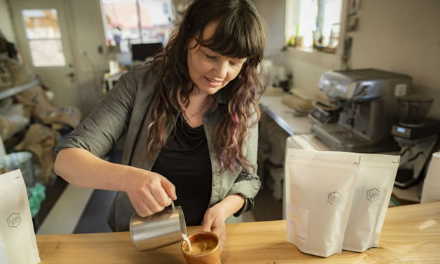 Ilana Cameron, owner of Lark Coffee, pouring a cup of coffee. 