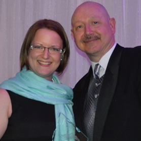 Lisa Barnes holding her Customer Service Excellence award, standing beside Darcy Kennedy