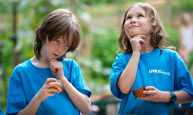 Two kids wearing bright blue t-shirts with Live-It logo. 