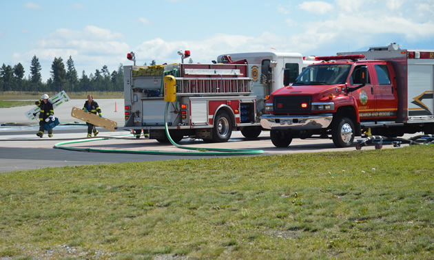 Firefighters carry medical equipment from their truck