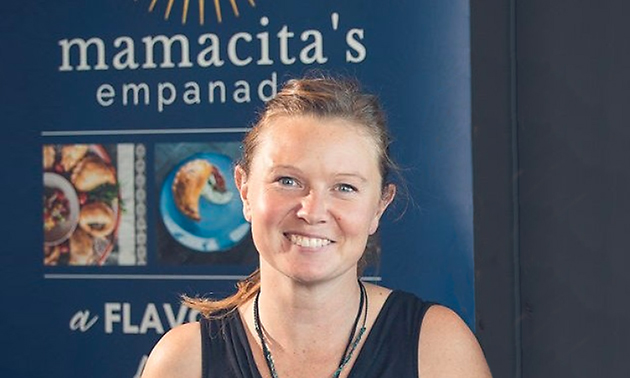 Jess Paloposki, owner of Mamacita’s Empanadas in Golden, B.C., standing in front of sign. 