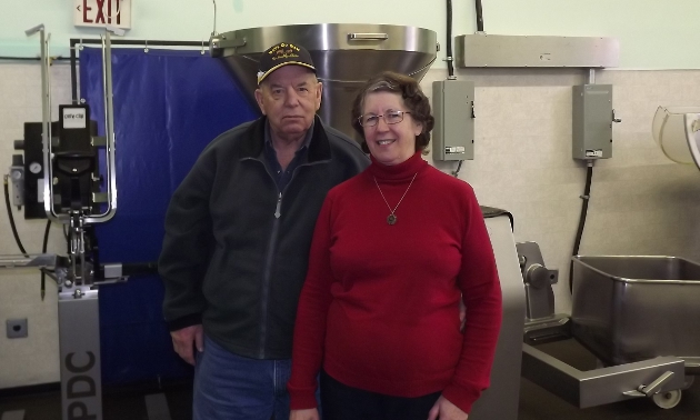 Man and woman in front of machinery