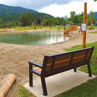 A bench overlooking the bottom pond and water slides at the Millennium Park Natural Outdoor Swimming Ponds project in Castlegar, B.C.