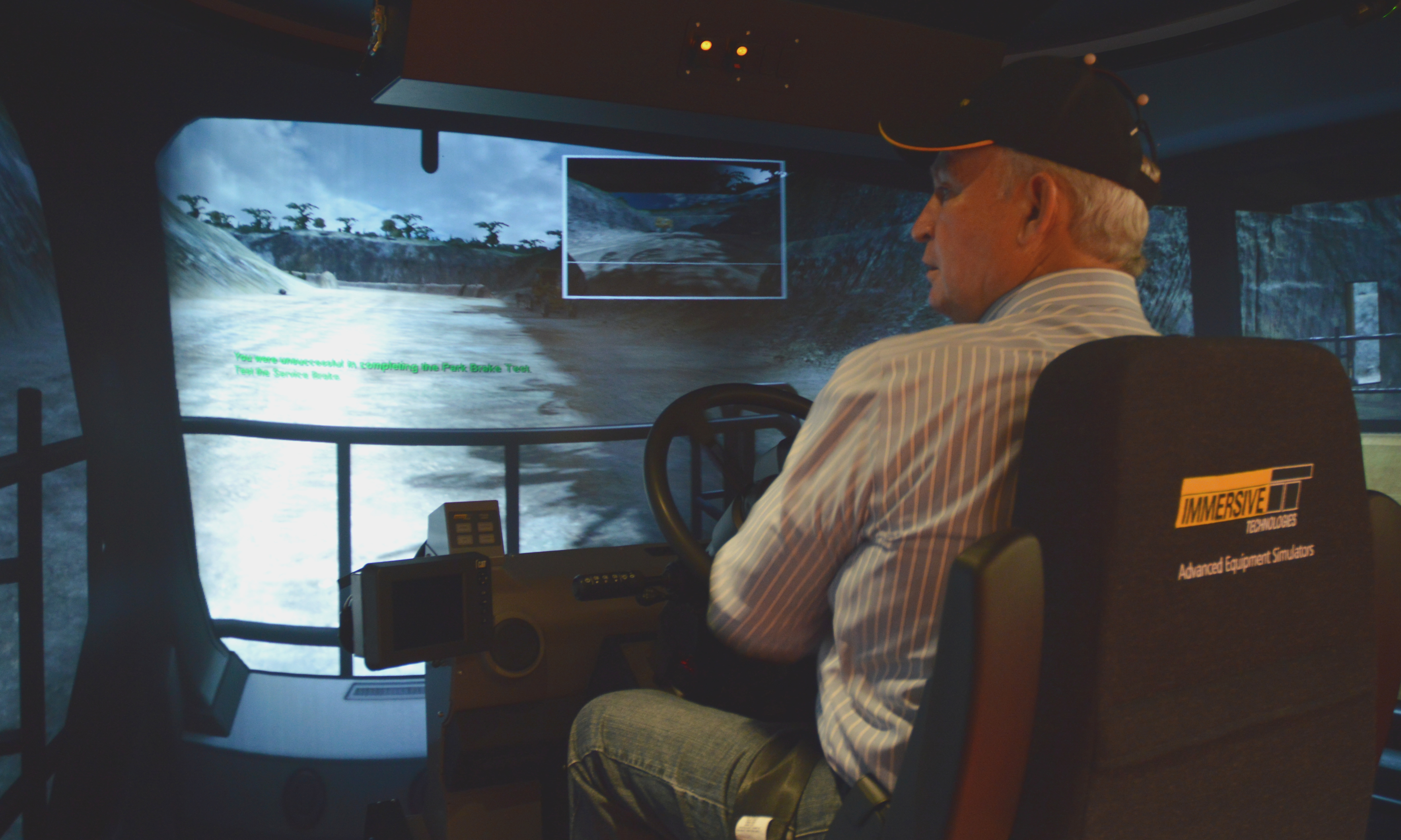 Government Minister Bill Bennett operates a haul truck simulator.