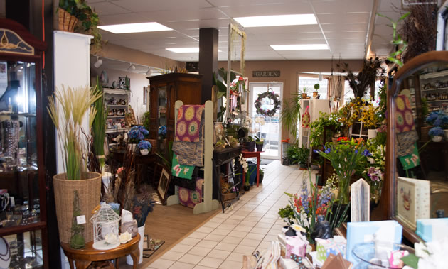 The interior of a shop is full of numerous wares flanking the aisle.