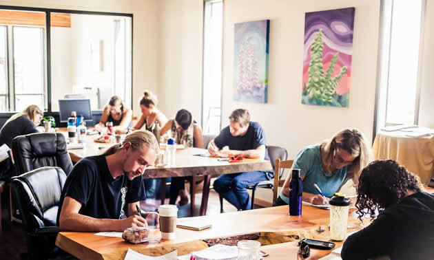 People in large room using co-working spaces. 