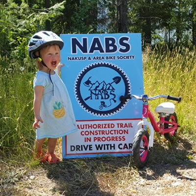 Little Nieve Thomas standing in front of a NABS construction sign. 