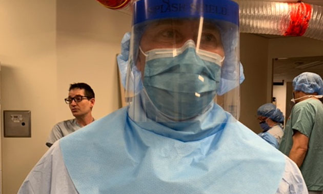 Medical doctor wearing neck guard and face shield. 