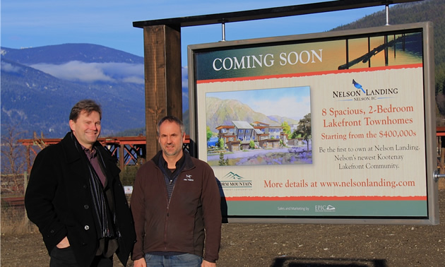 Allard Oakelon and Peter Ward stand next to a sign detailing the Nelson Landing development.