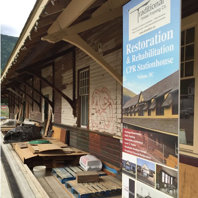 Picture showing a run-down railway station with a sign detailing the restoration project the building is undergoing. 