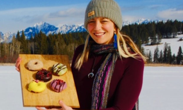 Nicole Corbo standing with a plate of donuts. 