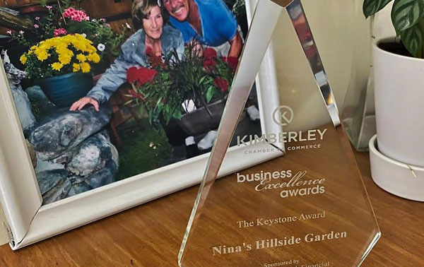Close-up photo of award, framed picture of couple in background. 