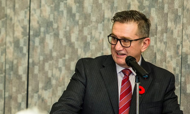 Norm McInnis addresses a group from a speakers' platform